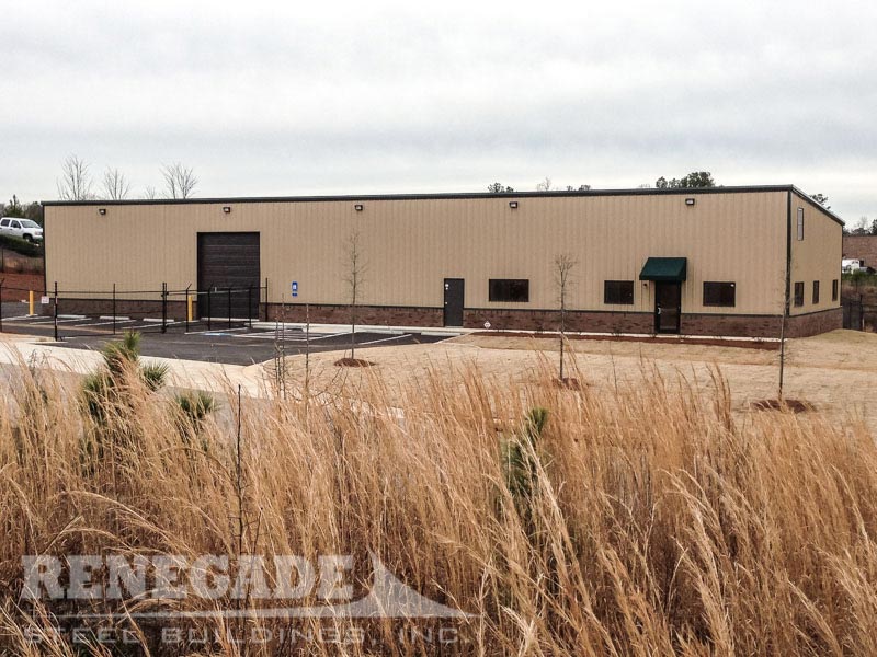 tan steel building with brown trim, brick wainscot, roll up doors, office and warehouse