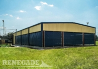 steel building with partially open walls with wind screens used for batting cages