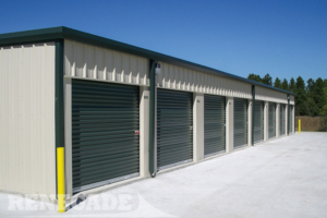 steel mini self storage tan building with green trim, roll up doors