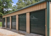 Renegade steel building mini warehouse with tan walls and green trim and rollup doors