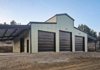 R-61 Monitor style steel building with a lean to on each side, featuring Light Stone wall panels and Burnished Slate roof and trim