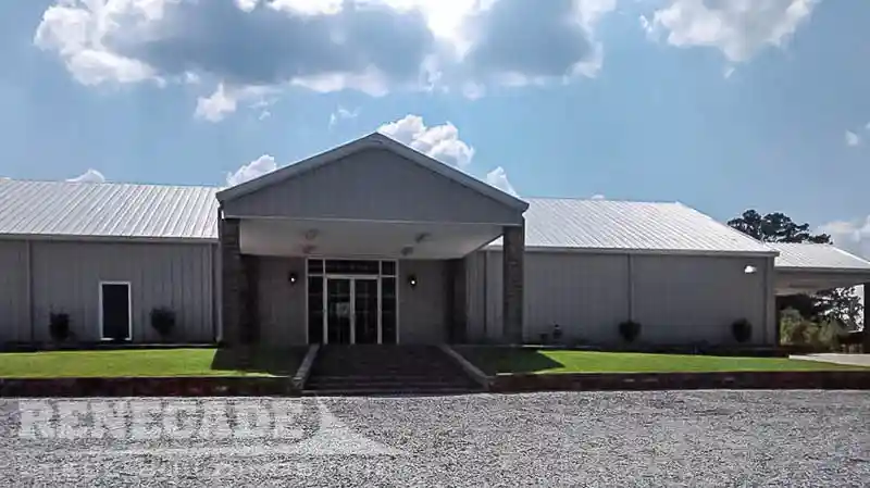 Gray steel building used for a church with drive under portico and entrance portico.