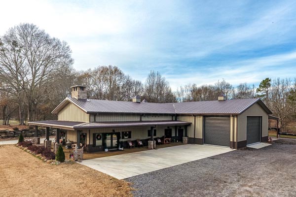 Renegade Steel Building Barndominium with tan walls and brown trim. Includes two buildings, a lean to and a wrap around porch.