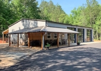 R54 45x65x14 Renegade steel building with wrap around porch and large glass roll up doors