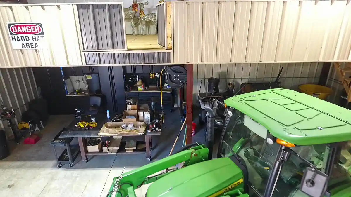 Interior of a workshop garage with a green tractor, and tool bench